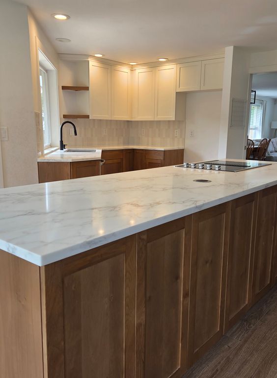 After: Beautiful, newly-renovated countertop, sink, cabinets, shelves, and a large separated island with a built-in stovetop and modern aesthetics. A major upgrade in form and function!