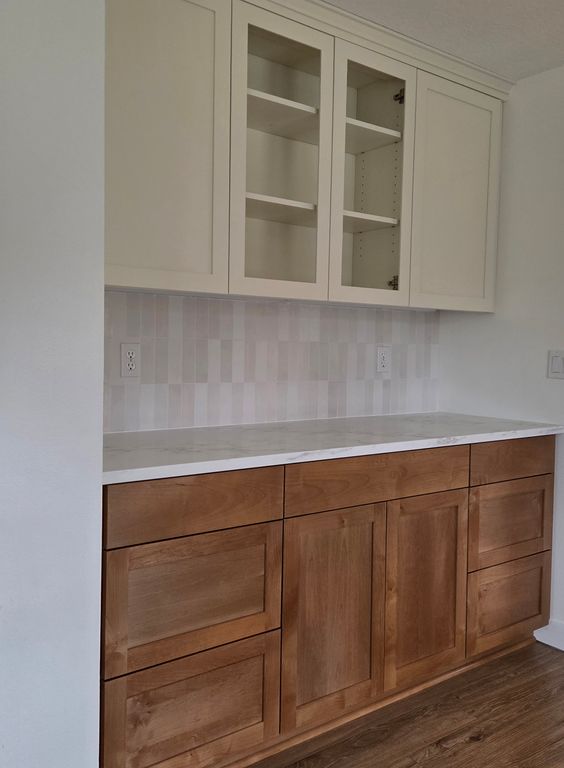 Custom cabinets, cupboards, and a stylish countertop and backsplash provide better storage and a cozy coffee service area