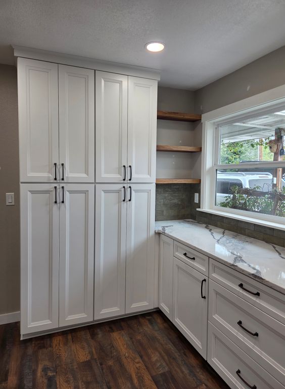 After: New floor-to-ceiling custom cabinets and floating walnut shelves add more storage with a modern look