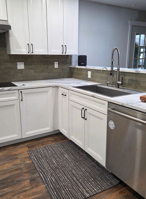 After: Brand new flooring, sink, cabinets, countertops, natural stone backsplash, and cupboards with a built-in stove and vent transform this space into a dream kitchen